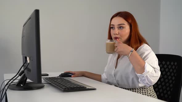 Woman Drinking Coffee While Working on Computer in Office 4K