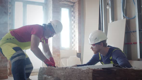 Workers Insulating a Room Wall with Mineral Rock Wool