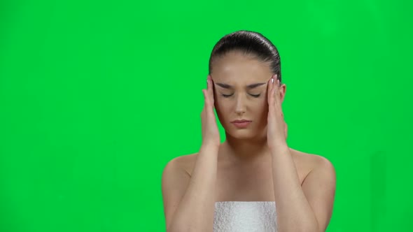 Spa Woman Suffering From Headache From Fatigue on Green Screen at Studio