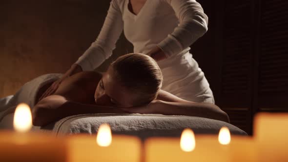 Young, healthy and beautiful woman gets massage therapy in the spa salon.