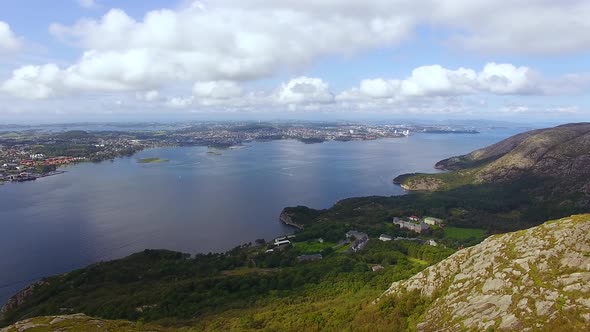 The woman is hiking on the top of a mountain in Norway, aerial view