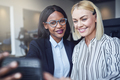 Smiling young businesswomen taking selfies in an office - PhotoDune Item for Sale