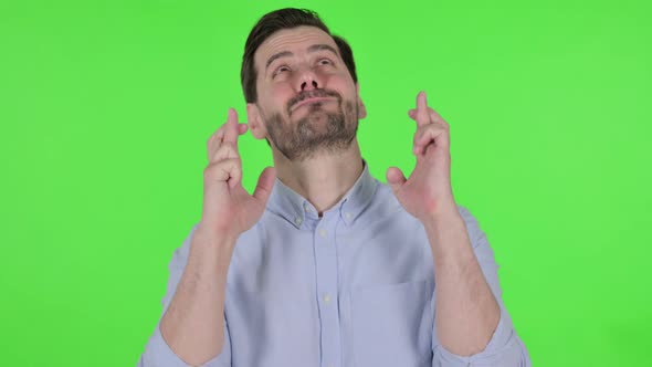 Portrait of Man Praying with Fingers Crossed Green Screen