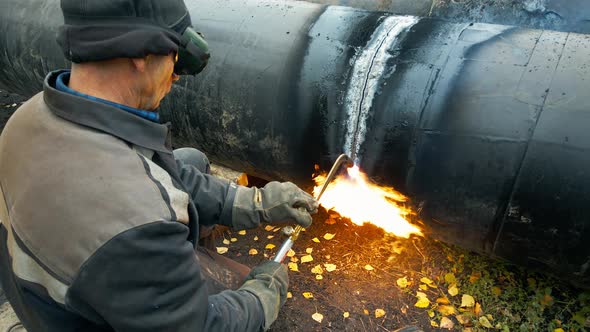 Welder at Work Cuts Metal Pipe