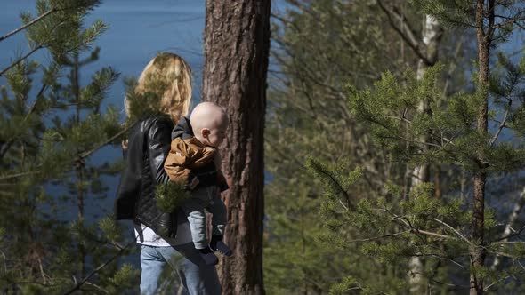 mom and baby walk in the forest by the lake