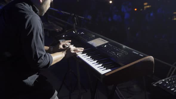A musician playing electone or piano on a stage playing rock perform on concert and live music