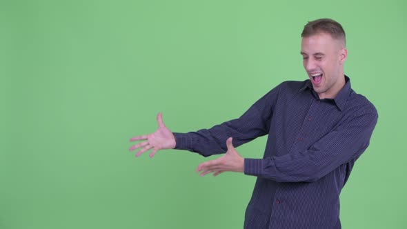 Happy Handsome Businessman Showing Something and Looking Surprised