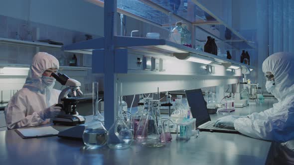 Scientists in Protective Coveralls Doing Research in Lab