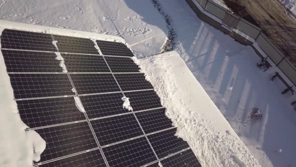 Closeup surface on a house roof covered with solar panels in winter with snow on top.