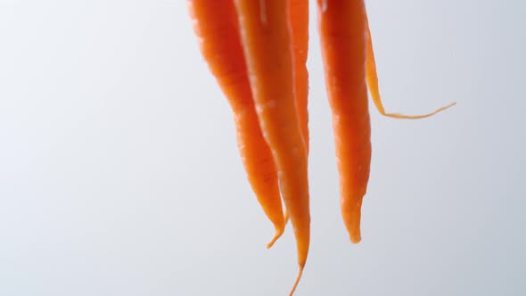 Camera follows cooking carrots in boiling water. Slow Motion.