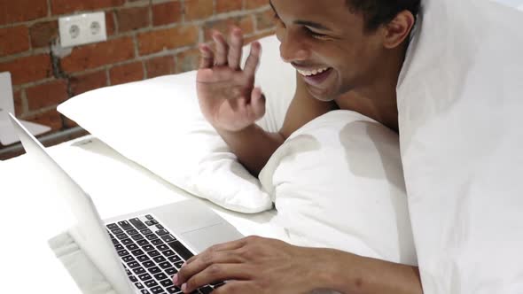 Online Video Chat By African Man Lying on Stomach at Night