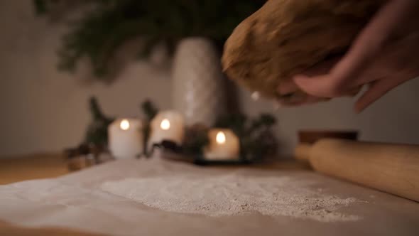 A Woman Rolls Out a Lump of Dough with a Rolling Pin