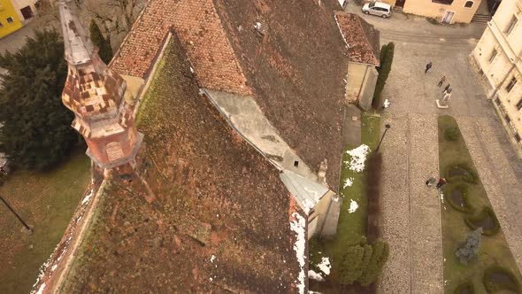 A approaching drone shot, capturing the rooftops of a vintage locality in the city of Sighisoara on
