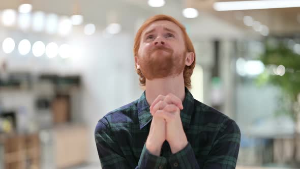 Portrait of Hopeful Young Beard Redhead Man Praying