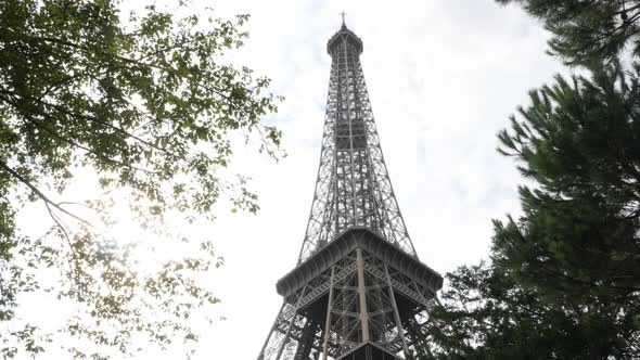 Construction of Eiffel tower  against sun and Parisian sky 4K 3840X2160 UltraHD footage - Monument o