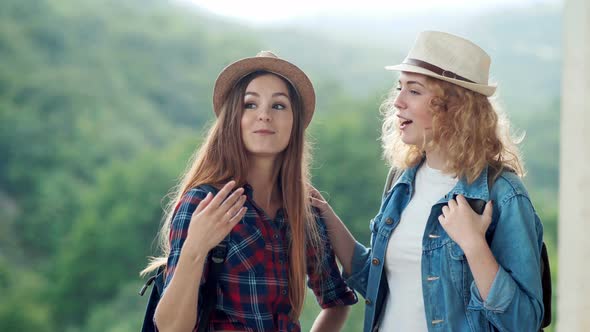 Two Pretty Girls Friends Travelers Discussing and Laughing Outdoors on Mountain Scene