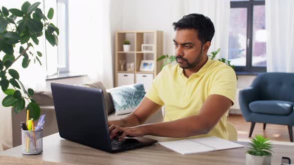 Indian Man with Notebook and Laptop at Home Office