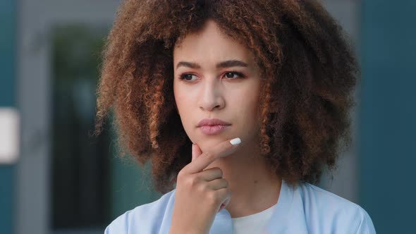 Millennial Black African American Young Pensive Girl Woman with Curly Hair Deep in Thoughts Thinking