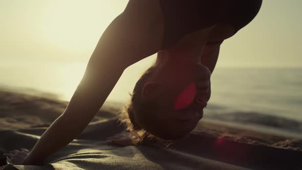 Yoga Woman Standing Downward Facing Dog Practicing Svanasana at Sunset Close Up