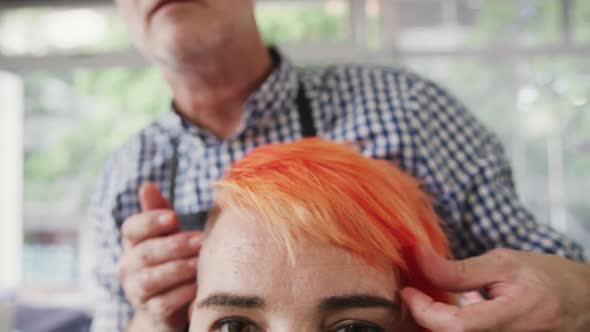 Front view hairdresser arranging woman hair