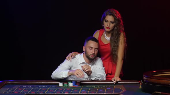 Man and Beautiful Girl in the Casino Wins in Roulette