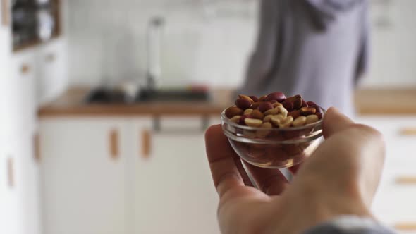 A Man Carries A Plate Of Peanuts In His Hand. A Bowl Of Peanuts. Intolerance To Peanuts, Allergy