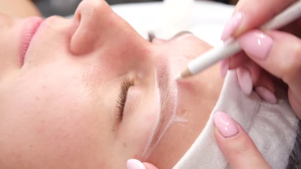 Permanent Makeup for Eyebrows of Woman with Thick Brows in Beauty Salon