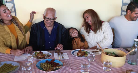 Happy latin family having fun eating together at home