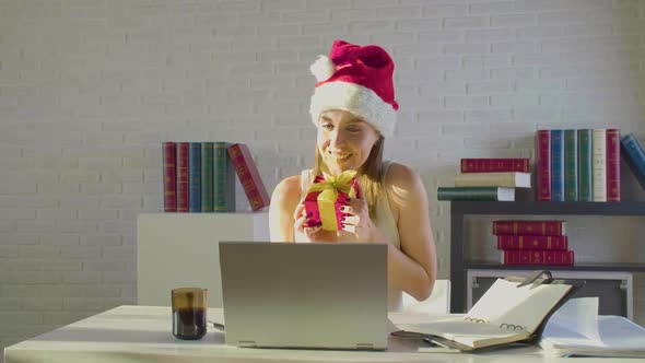 Front View Ov a Young Woman in the Office on Christmas Eve in Santa Hat