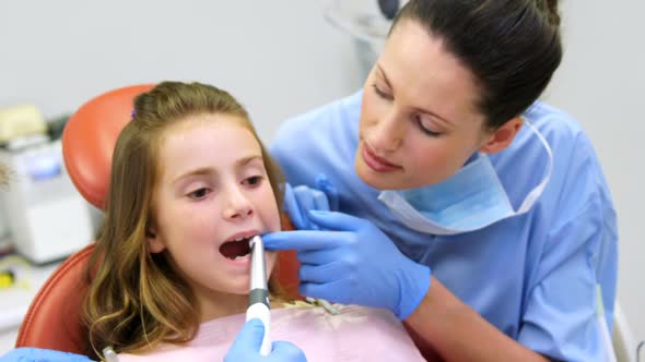 Dentist and nurse examining a young patient with tools
