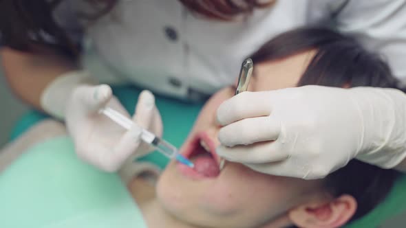 Dentist is treating a patient in a modern dental office. alt