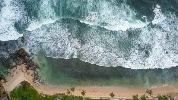 Ocean Waves with White Foam Roll on Yellow Sandy Coastline