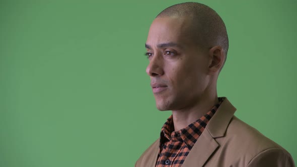 Closeup Profile View of Serious Bald Multi Ethnic Businessman Looking Around