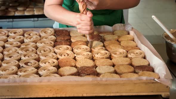 Confectioner Decorating Biscuits with Yummy Cream