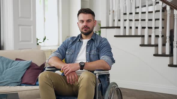 Sedentary Guy in Wheelchair Looking at Camera in Beautifully Designeted house