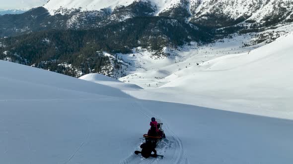 Snowmobile high in the mountains aerial view 4 K