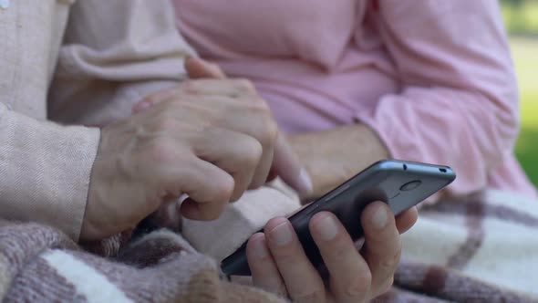 Aged Man Showing Woman Easy to Use Mobile App on Smartphone, Modern Technology