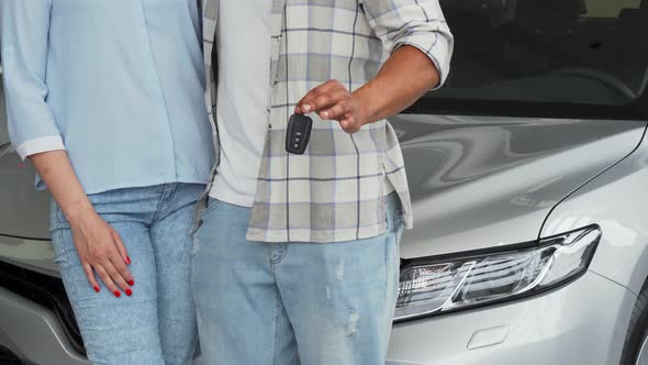 Couple Holding Car Keys Showing Thumbs Up