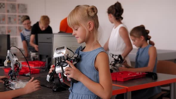 A Student Holds a Work Assembled From Plastic Parts in a Robotics Lesson