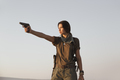 Woman Standing With a Gun Outdoors in Desert - PhotoDune Item for Sale
