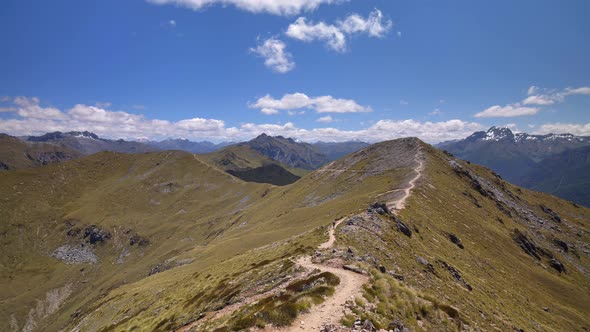 Static, distant hiker on exposed trail, vast mountain landscape, Fiordland, Kepler Track New Zealand