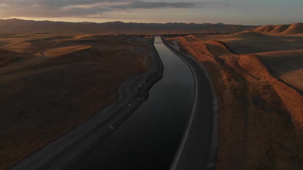 Golden hour aerial view of a water canal in southern California.  Drought conditions are apparent in