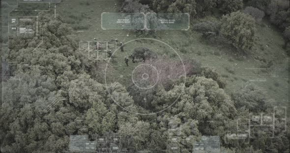 Surveillance drone view of soldiers walking through a forest with hud graphics