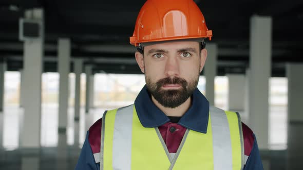 Portrait of Professional in Construction Uniform Standing Indoors with Building Zone in Background