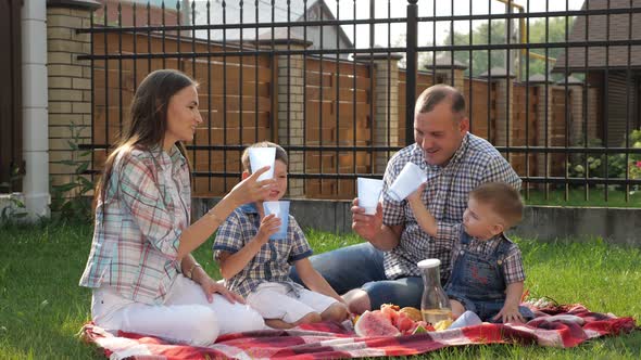 Handsome Man Pretty Woman and Adorable Boys Enjoy Picnic