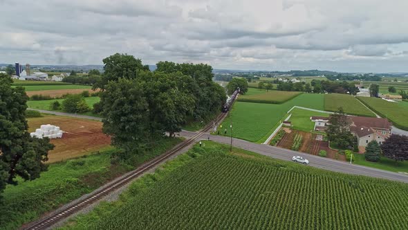 Aerial View Traveling In Front of An Antique Steam Passenger Train Blowing Smoke