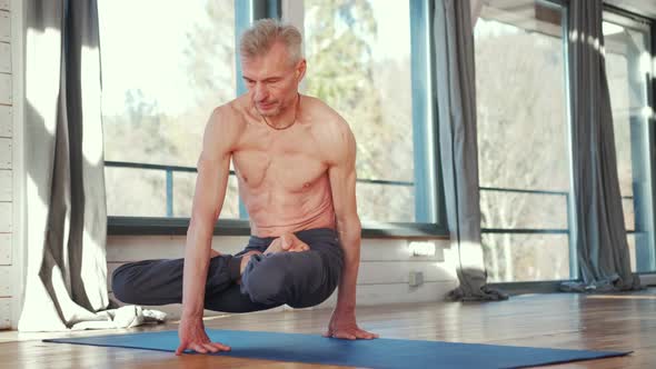 Mature Man Amongst Doing Power Yoga Exercises