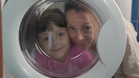 Mother with child by washing machine.