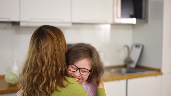 Sweet Down Syndrome Daughter Hugging with Her Mom