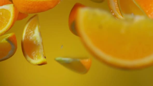 Juicy Delicious Slices of Ripe Orange are Bouncing on the Yellow Background